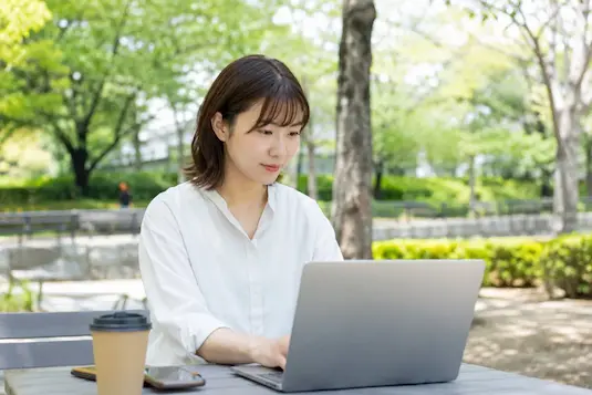 公園でPC作業をする女性